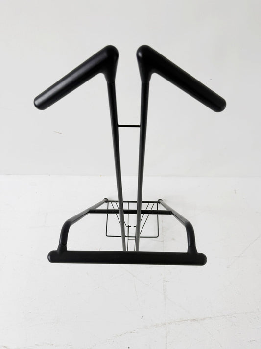 Appendiabiti da terra pieghevole in tubolare metallico verniciato nero, con struttura a montanti incrociati.