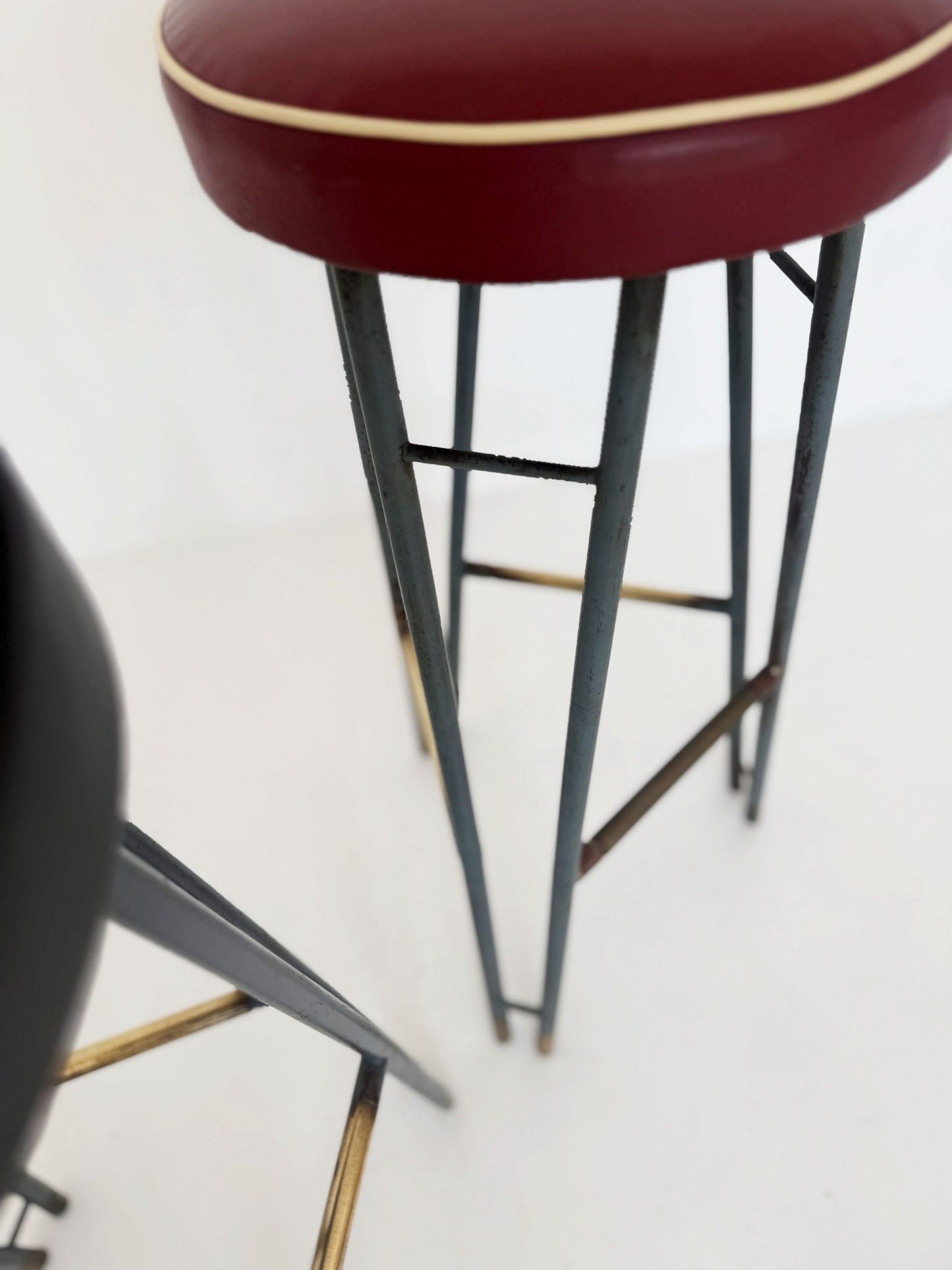 Una coppia di sgabelli alti con struttura in metallo verniciato, caratterizzati da un design elegante