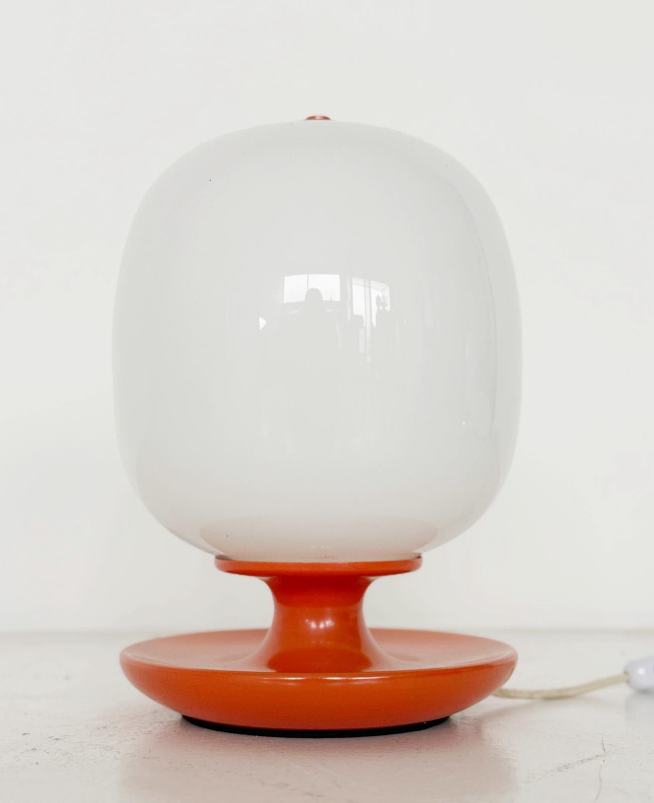 Table lamp with orange base and white glass diffuser