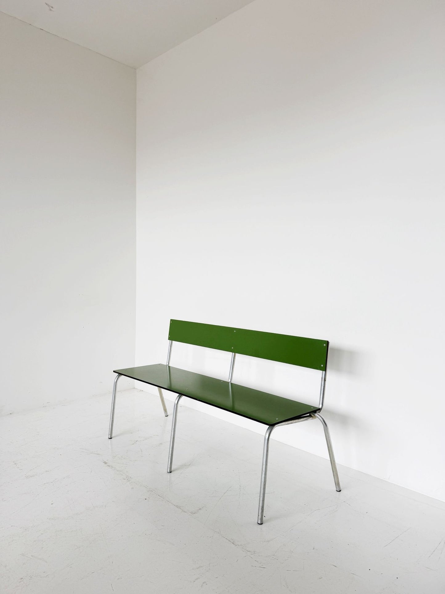 Green metal bench with tubular structure