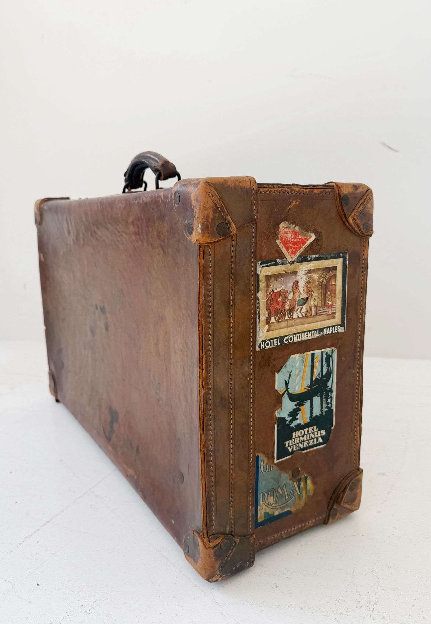 Leather travel suitcase with hotel labels