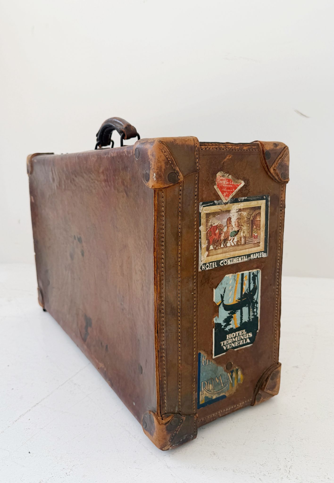 Valigia da viaggio in pelle con etichette alberghiere