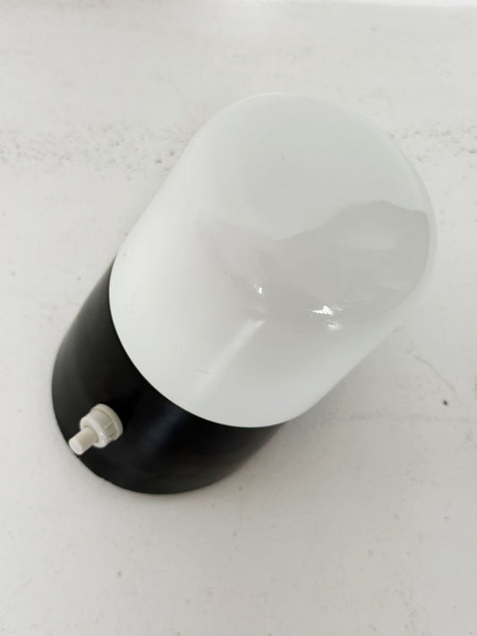 Small wall sconce with a white opal diffuser and a black plastic base