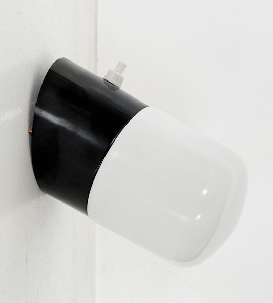 Small wall sconce with a white opal diffuser and a black plastic base