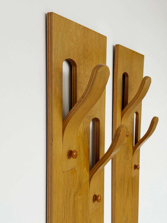 A pair of wall-mounted coat racks composed of two independent vertical modules,