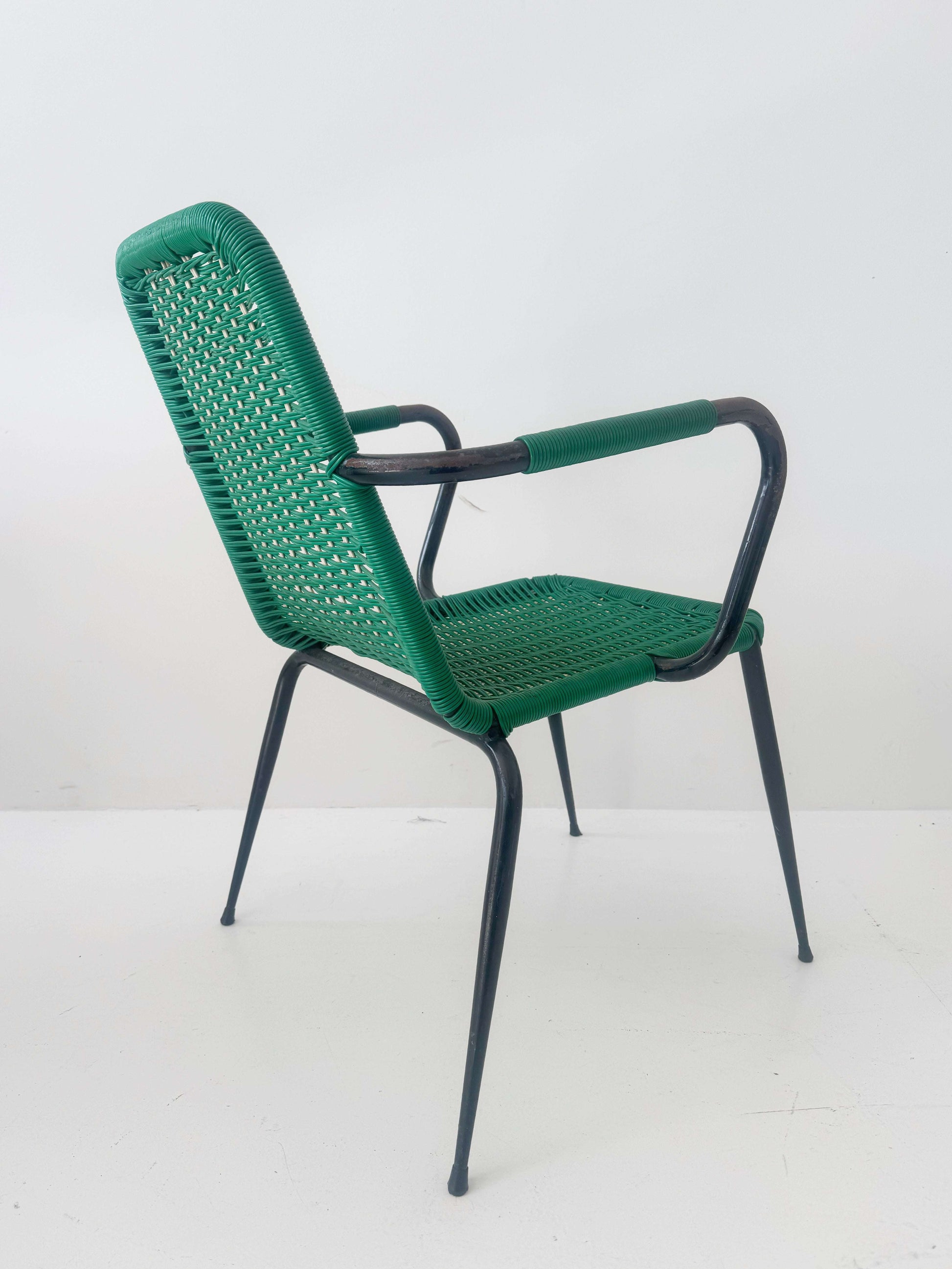 Green woven chair with armrests