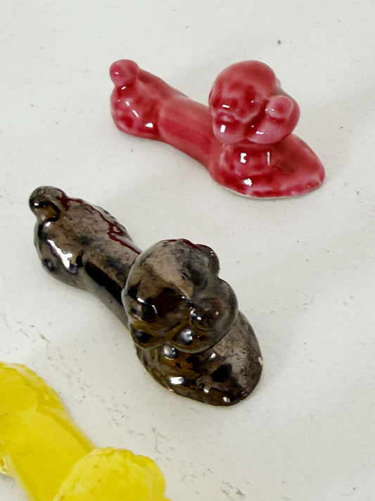 Set of four glazed ceramic cutlery rests in the shape of a reclining poodle
