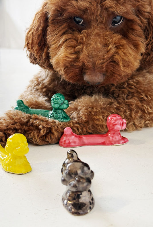 Set of four glazed ceramic cutlery rests in the shape of a reclining poodle