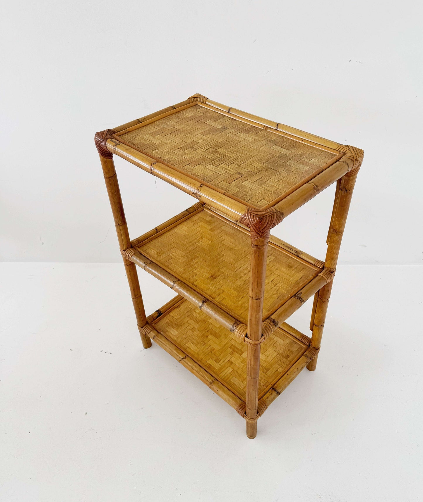 A 1970s bamboo bookcase with three shelves and woven details