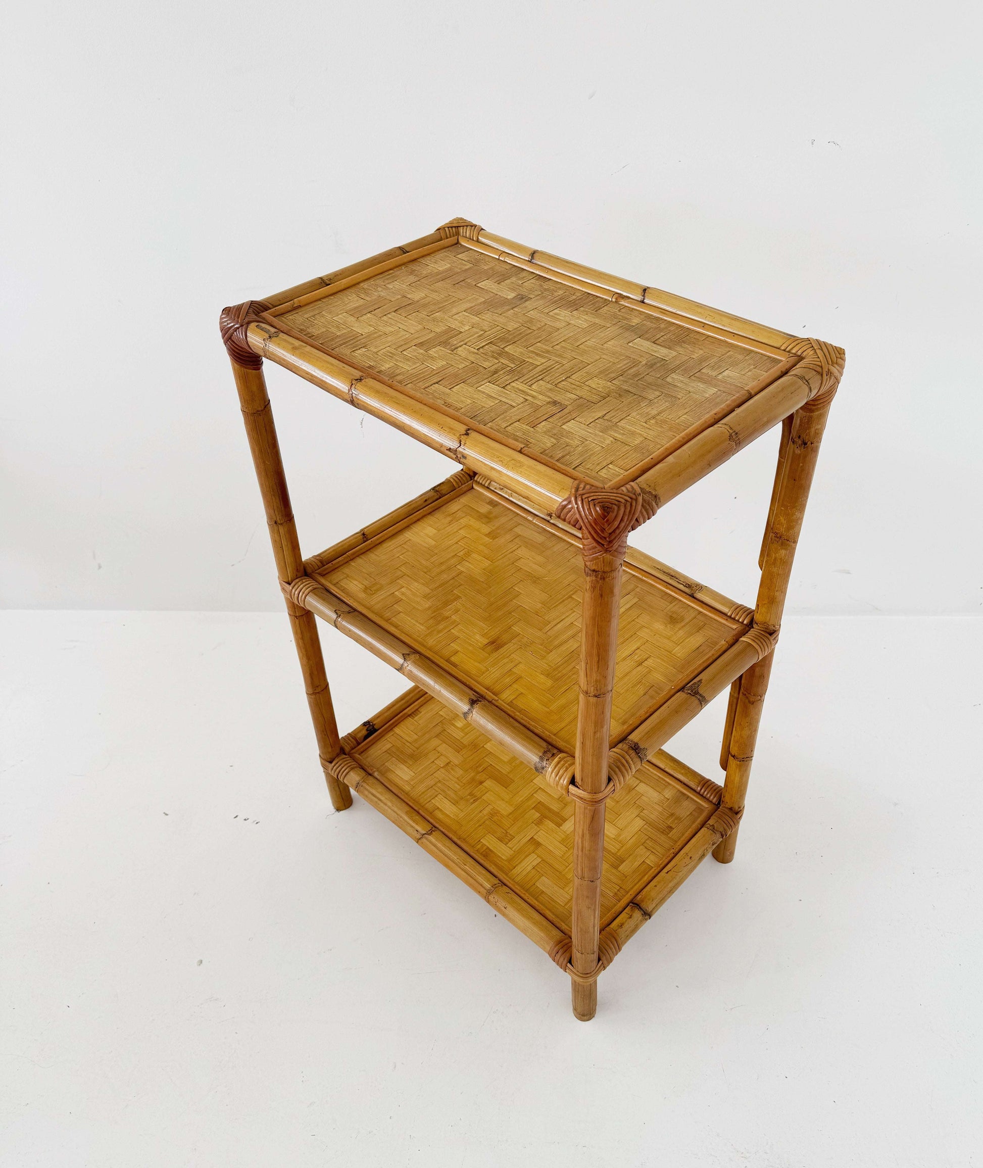 A 1970s bamboo bookcase with three shelves and woven details