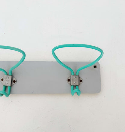 1960s wall mounted coat rack with coated metal hooks