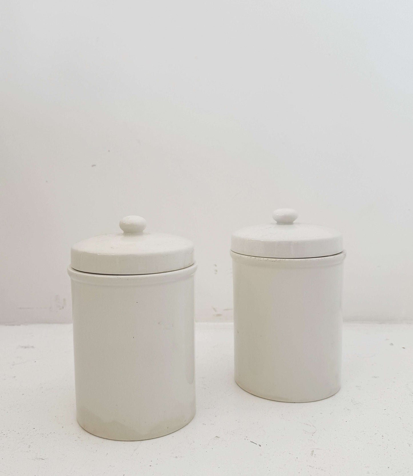 Pair of white ceramic jars with lids