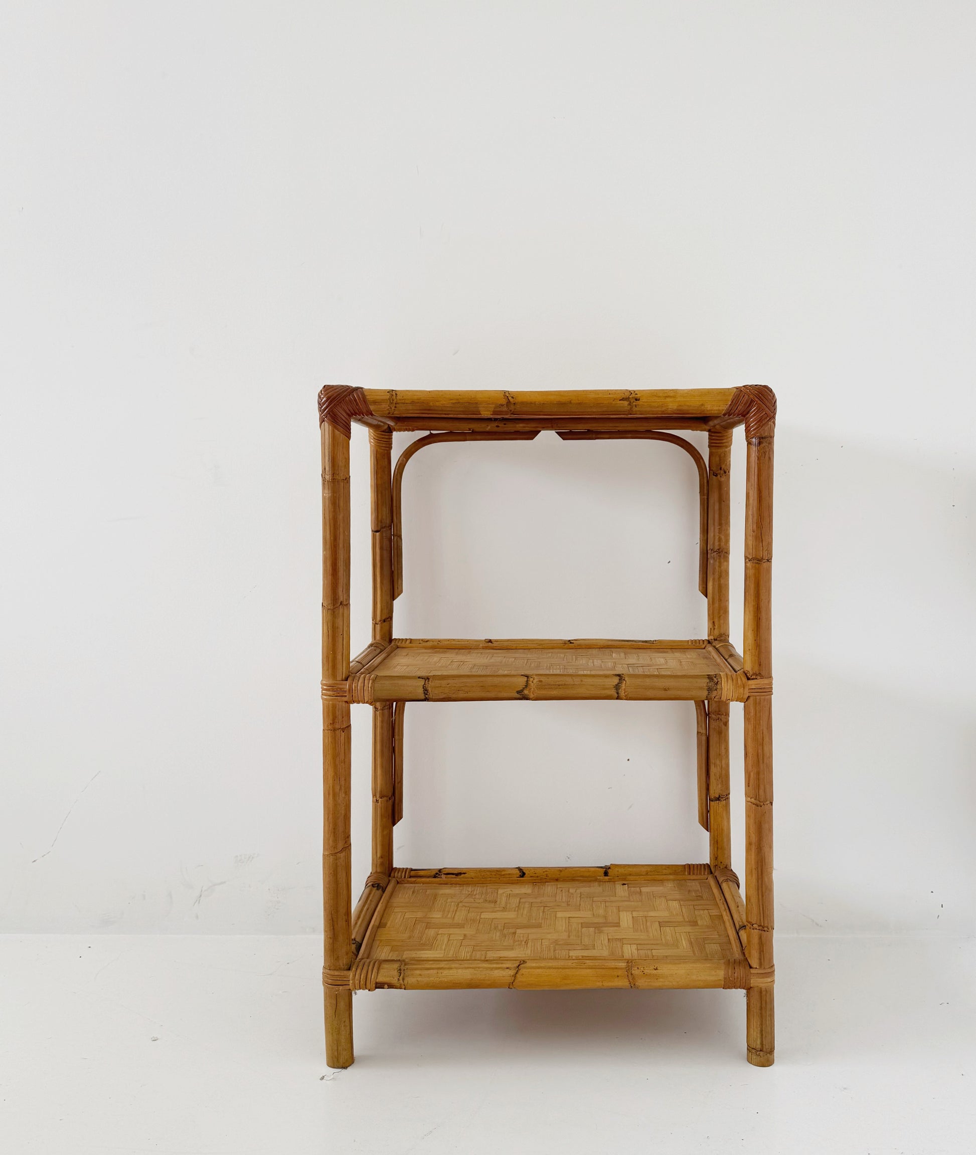 A 1970s bamboo bookcase with three shelves and woven details