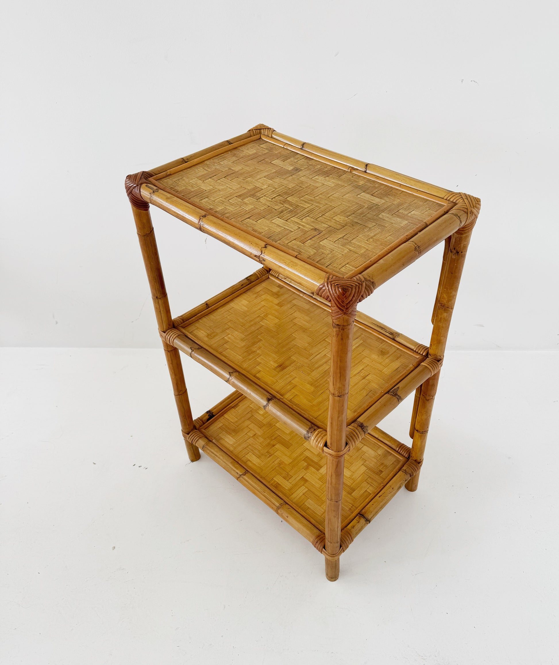 A 1970s bamboo bookcase with three shelves and woven details