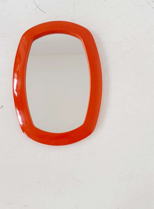Vintage mirror with an orange molded plastic frame