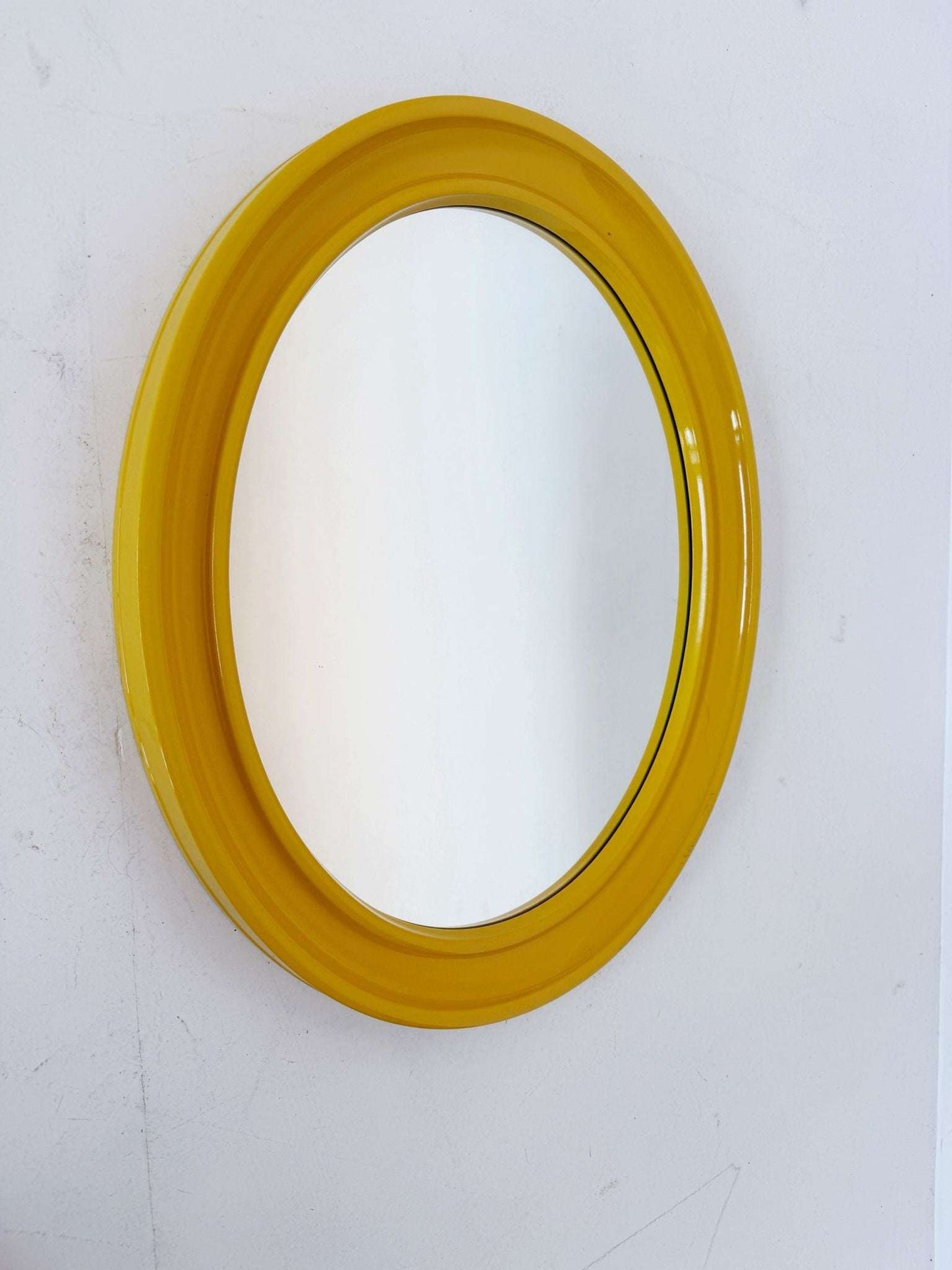 Oval wall mirror with yellow frame