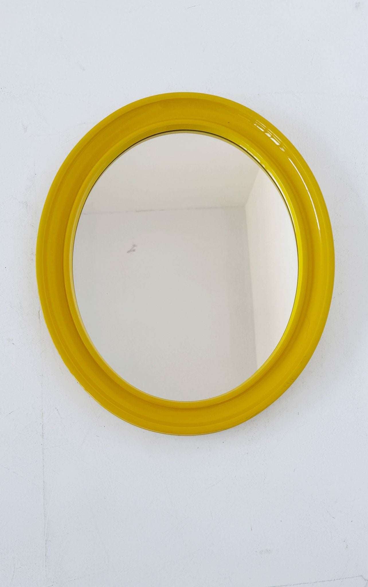 Oval wall mirror with yellow frame
