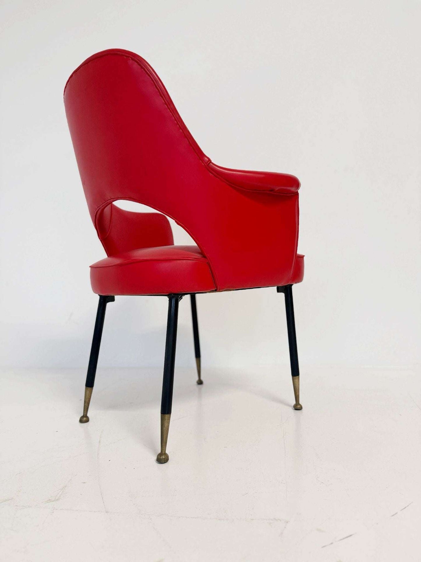 1950s Italian armchair in red vinyl, with a contoured back and open back.