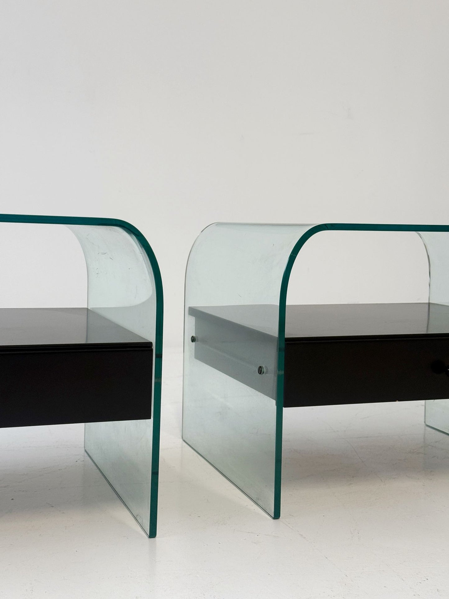 Coppia di tavolini in vetro curvato con cassettiera nera