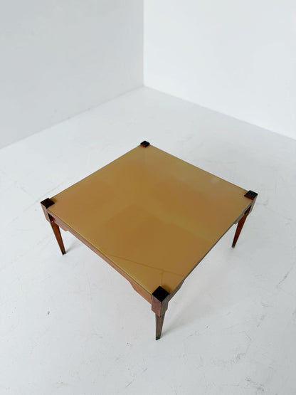 This mid-century coffee table features a solid wood frame and tapered