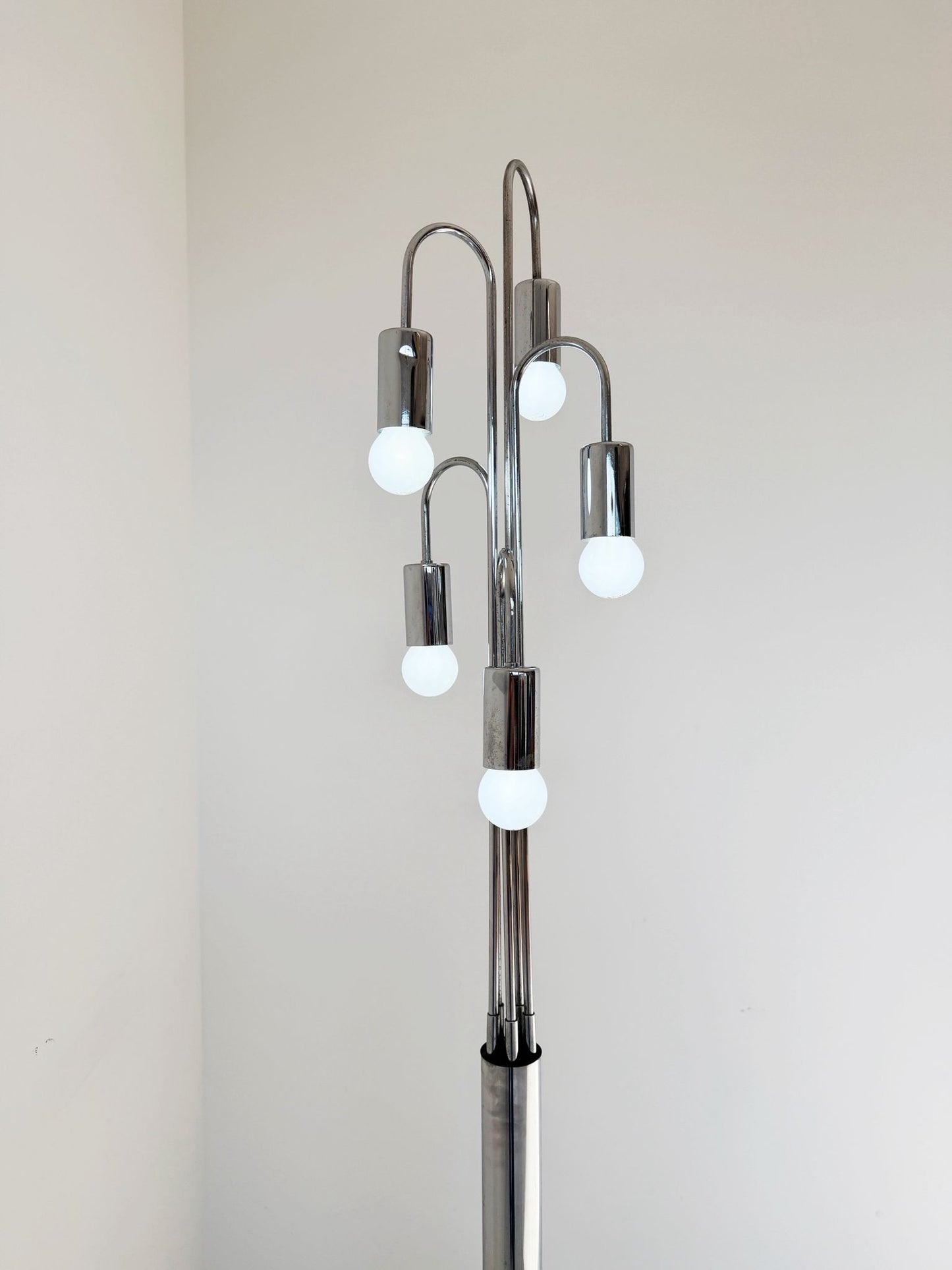 Lampada da terra vintage in metallo cromato, dal design scultoreo e luminoso.