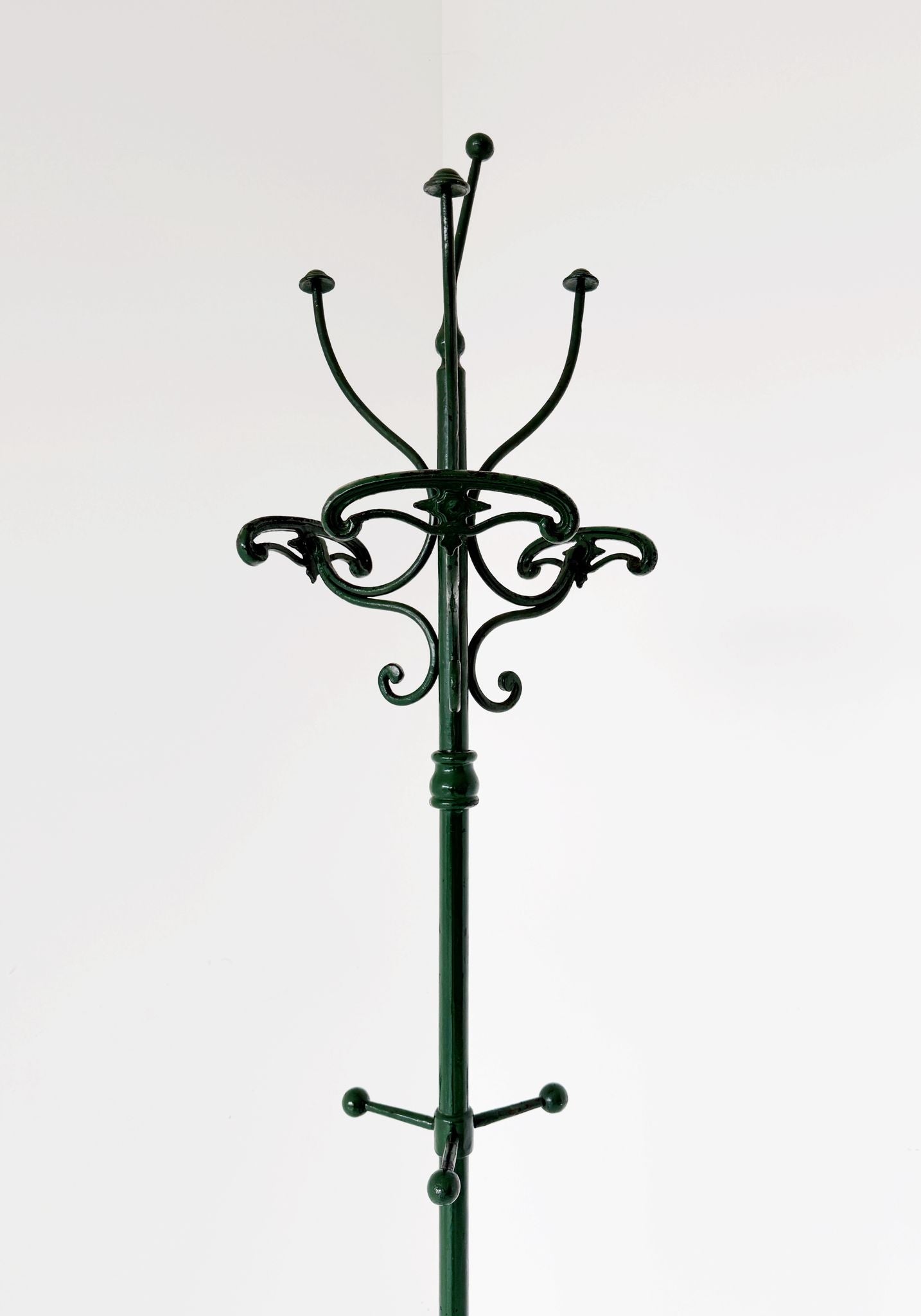 Floor coat rack made of dark green painted iron.