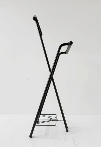 Appendiabiti da terra pieghevole in tubolare metallico verniciato nero, con struttura a montanti incrociati.
