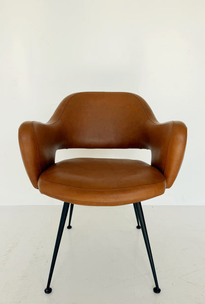 Poltroncina imbottita in pelle color cognac con struttura in metallo nero, anni ’50/’60.