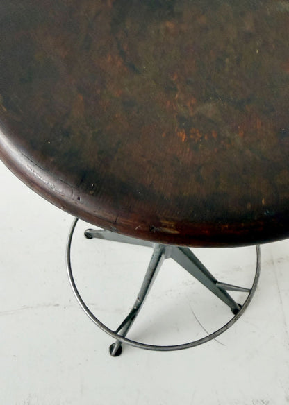 An adjustable industrial stool with a distinctly workshop/laboratory feel, boasting a strong, authentic presence.