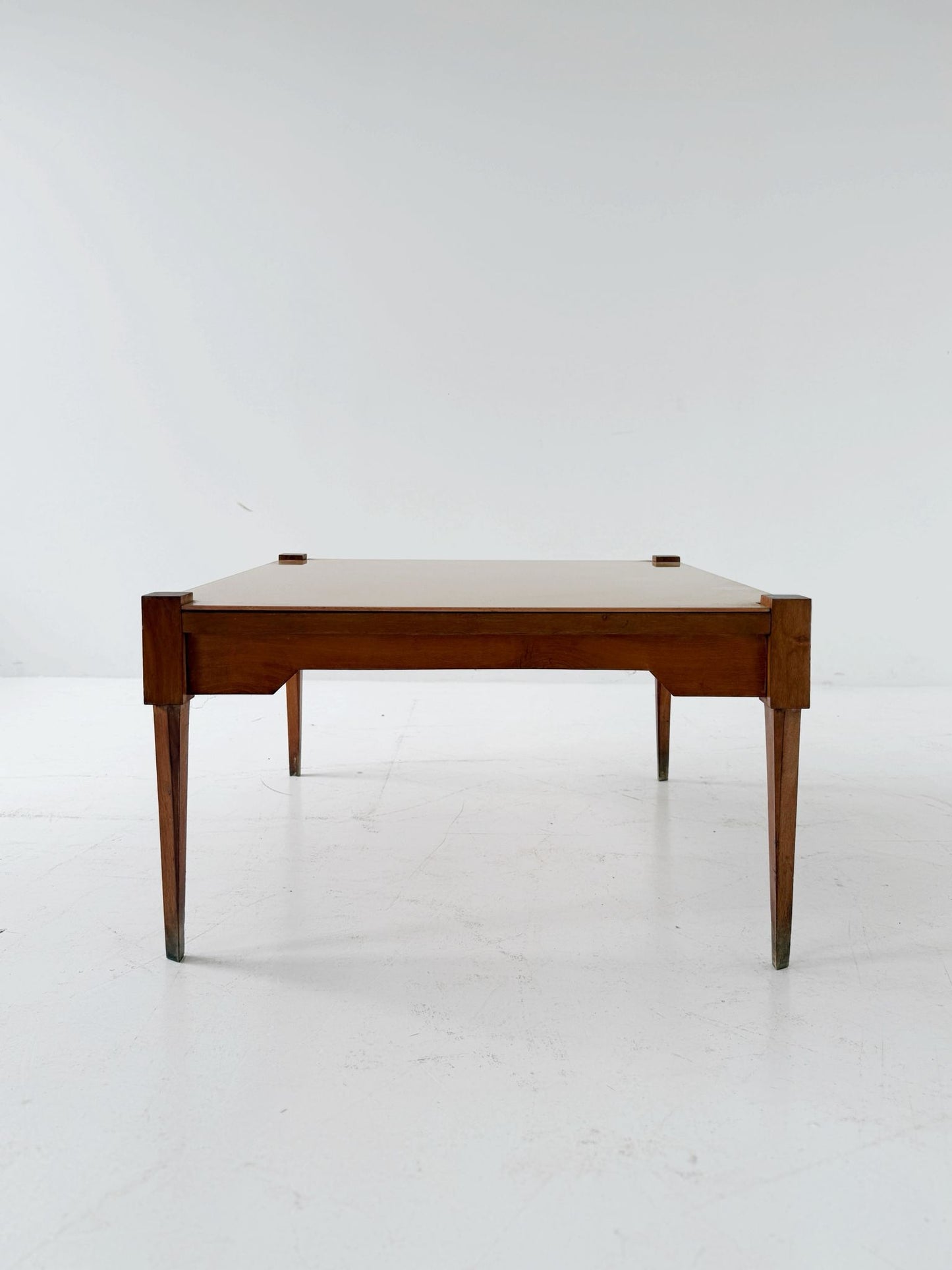 This mid-century coffee table features a solid wood frame and tapered