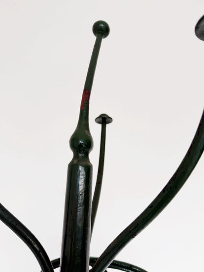 Floor coat rack made of dark green painted iron.