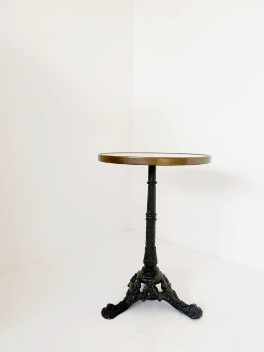 Bistro table with a round white Carrara marble top and burnished brass edge.