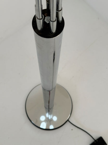 Lampada da terra vintage in metallo cromato, dal design scultoreo e luminoso.