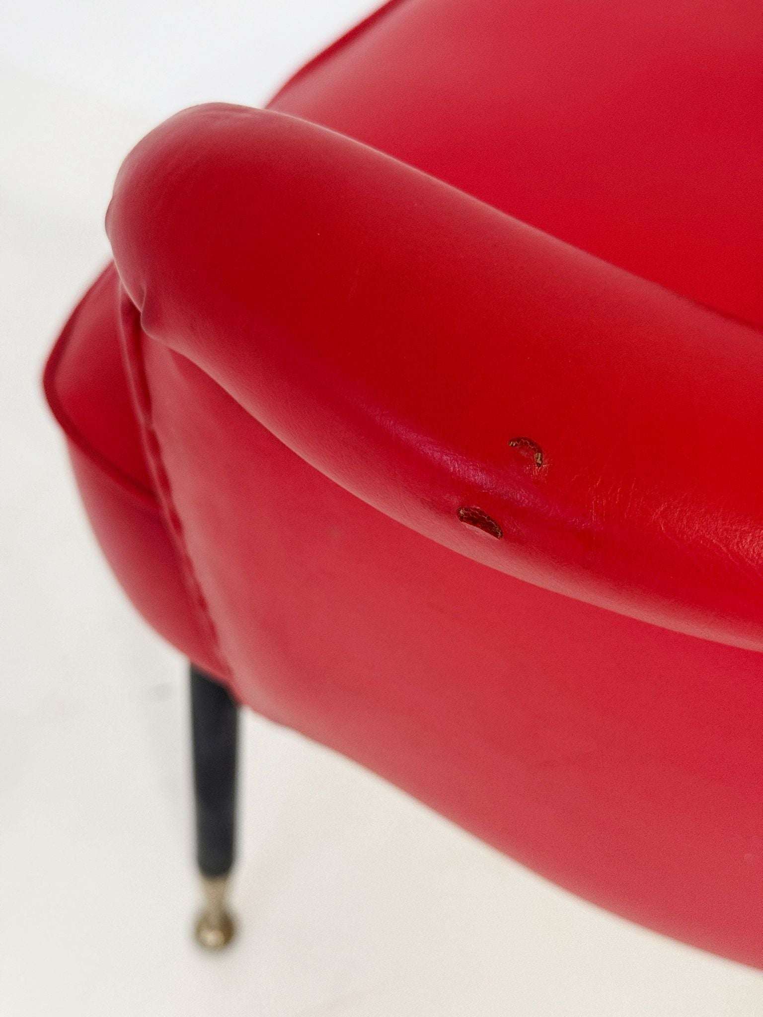 1950s Italian armchair in red vinyl, with a contoured back and open back.