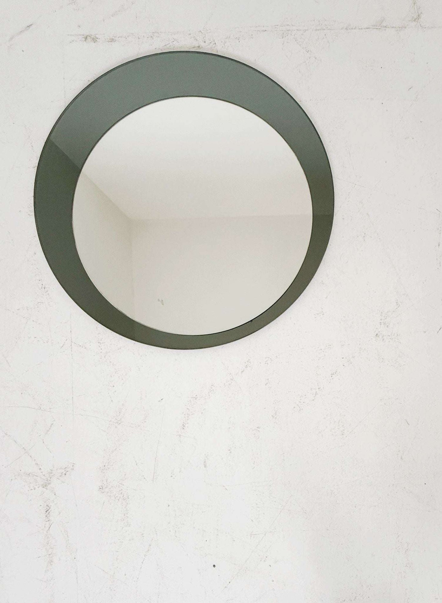 Circular wall mirror composed of two overlapping elements: