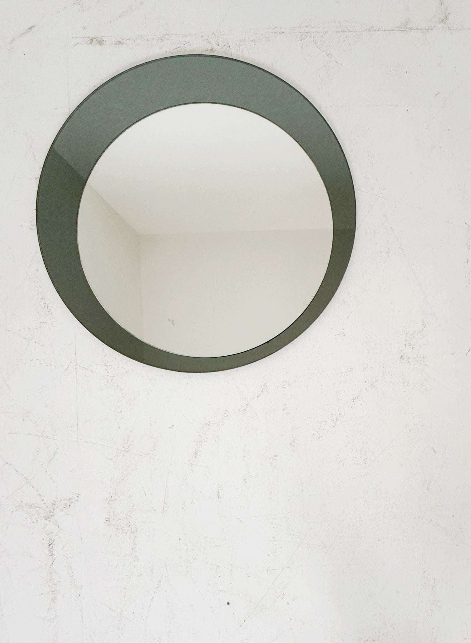 Circular wall mirror composed of two overlapping elements: