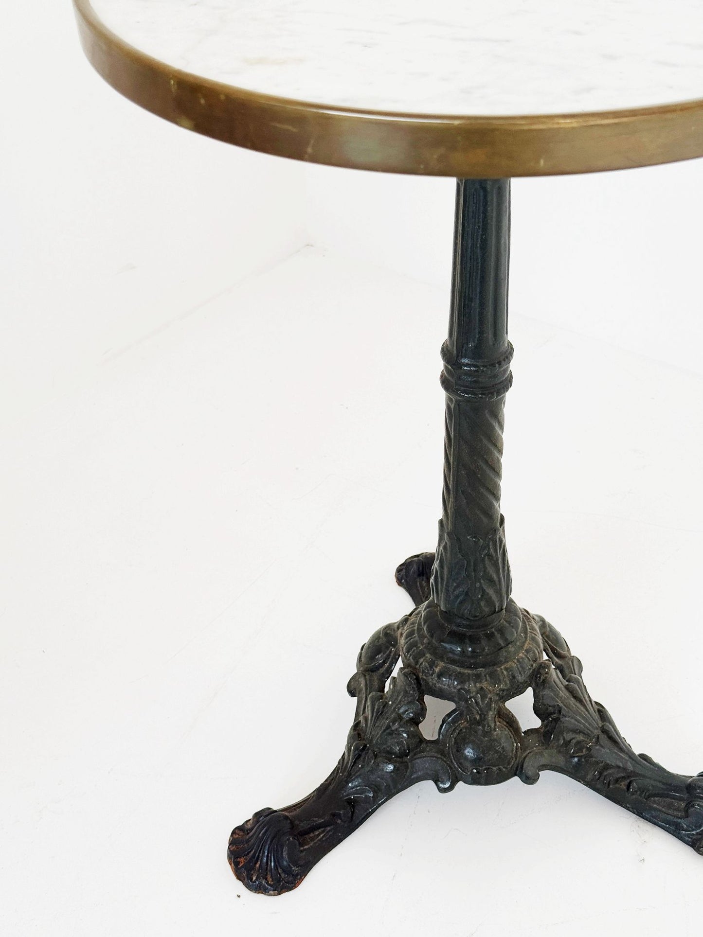 Bistro table with a round white Carrara marble top and burnished brass edge.