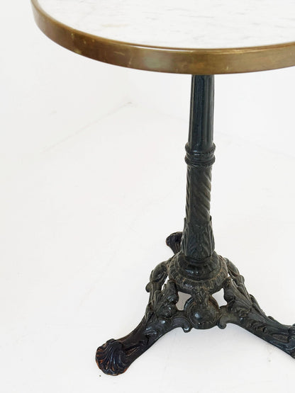 Bistro table with a round white Carrara marble top and burnished brass edge.