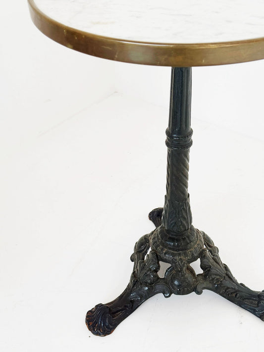 Bistro table with a round white Carrara marble top and burnished brass edge.