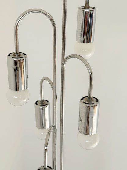 Lampada da terra vintage in metallo cromato, dal design scultoreo e luminoso.