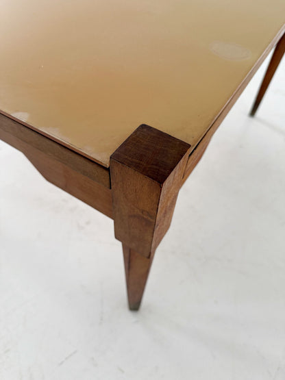 This mid-century coffee table features a solid wood frame and tapered