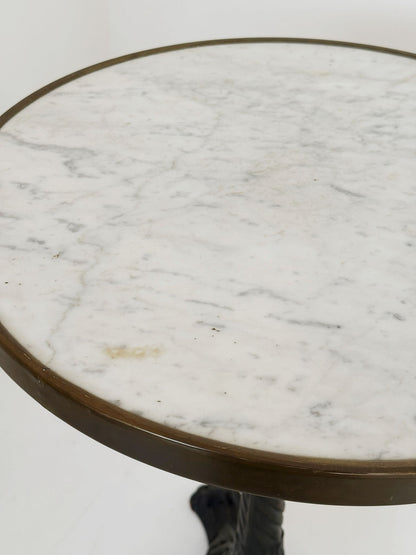 Bistro table with a round white Carrara marble top and burnished brass edge.