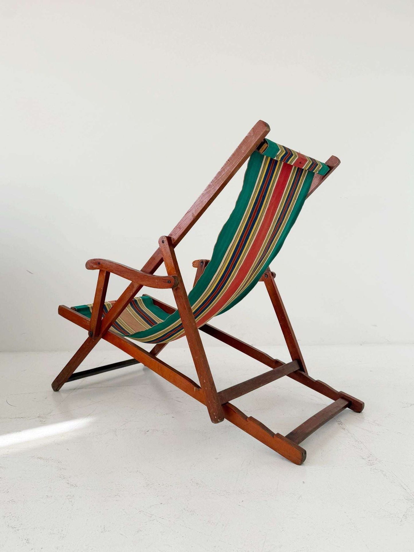 Folding wooden deck chair with striped canvas seat