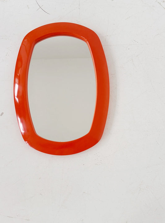 Vintage mirror with an orange molded plastic frame