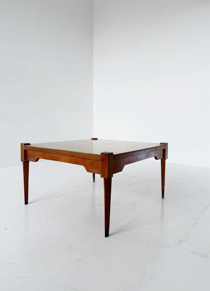This mid-century coffee table features a solid wood frame and tapered