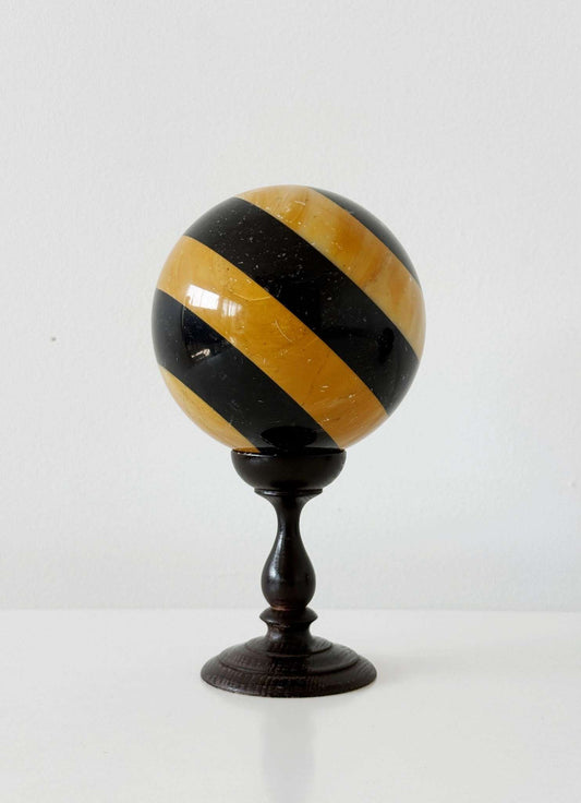 Decorative sphere of polychrome onyx on a turned, ebonized wood base