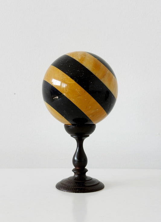Sfera decorativa in onice policromo su base tornita in legno ebanizzato
