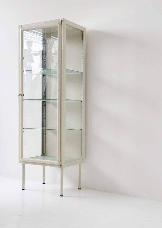 This ivory-colored lacquered metal display cabinet features a simple, functional design