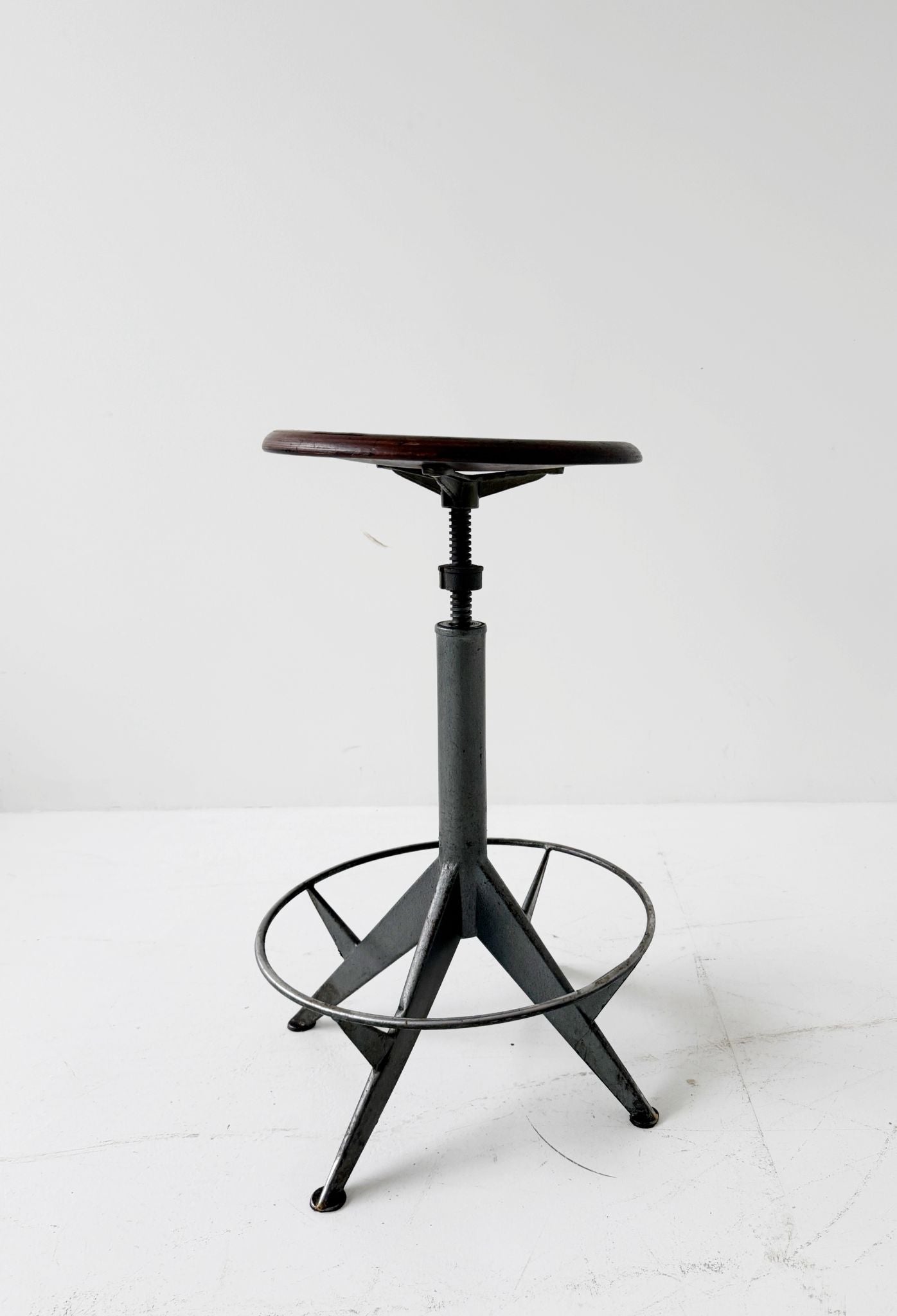 An adjustable industrial stool with a distinctly workshop/laboratory feel, boasting a strong, authentic presence.