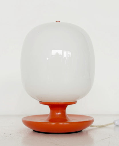 Table lamp with orange base and white glass diffuser